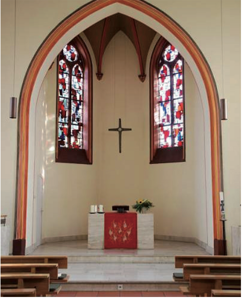 Schöne Kircheninnenraum mit bunten Glasfenstern und zentralem Altar.