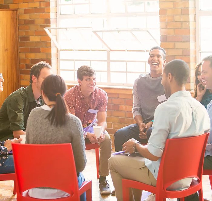 Eine fröhliche Gruppendiskussion in einem hellen Innenraum.