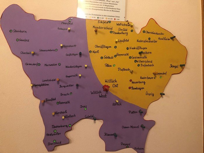 Handgemachte Karte mit bunten Stecknadeln für verschiedene Orte.