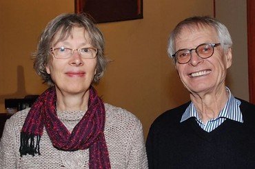 Lächelnder Mann und Frau mit Brillen in Innenraum.