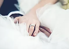 Ein romantischer Moment, in dem frisch Vermählte Händchen halten.