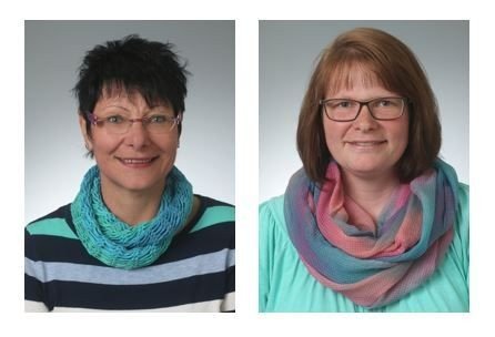 Zwei lächelnde Frauen mit Brillen, bunten Schals und lässiger Kleidung.